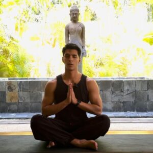Yoga instructor Mauricio in a calm starting pose on a yoga mat outdoors during a Livana Life Stress Relief session.